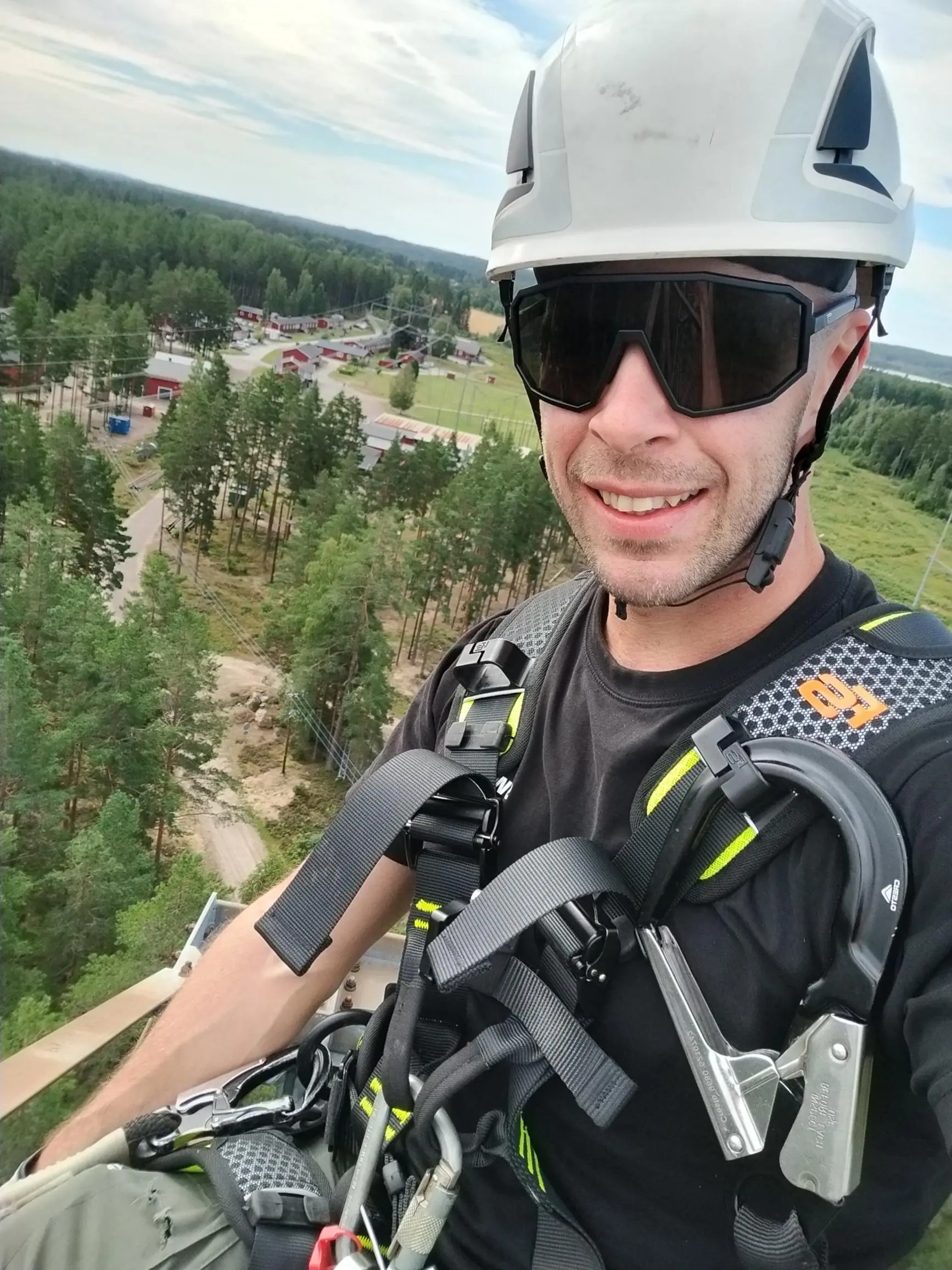 Bob Impola klättrar i elstolpe med skogen bakom sig.