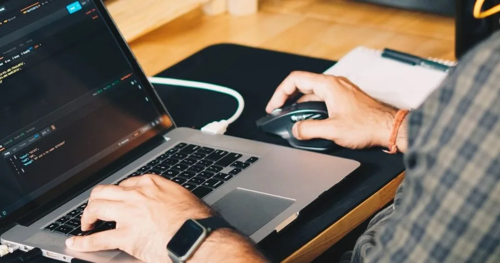 Utvecklare arbetar med programmeringsspråk på bärbar dator.