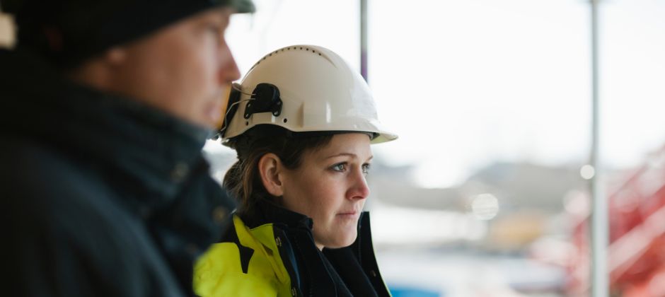 Byggledare i varselställ på byggarbetsplats.