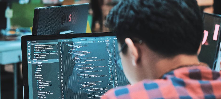 Ingenjör inom AI programmerar på dator.