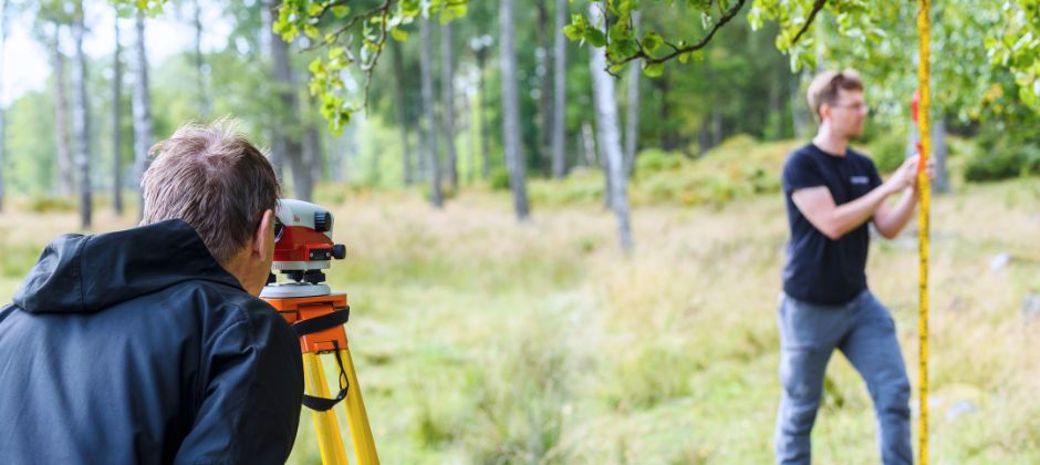 Mätningsingenjörer arbetar med mätinstrument i utomhusmiljö.