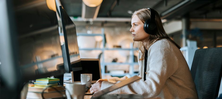 Kvinnlig NET-utvecklare arbetar framför dator i kontorsmiljö