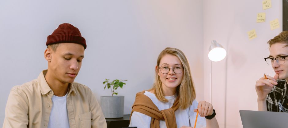 En grupp studerande studerar samlade runt ett bord.