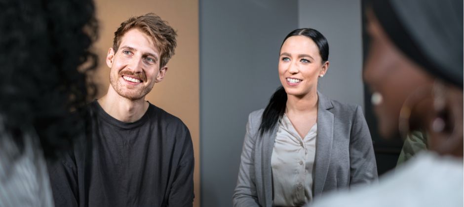 Fyra personer sitter mittemot varandra och ler.